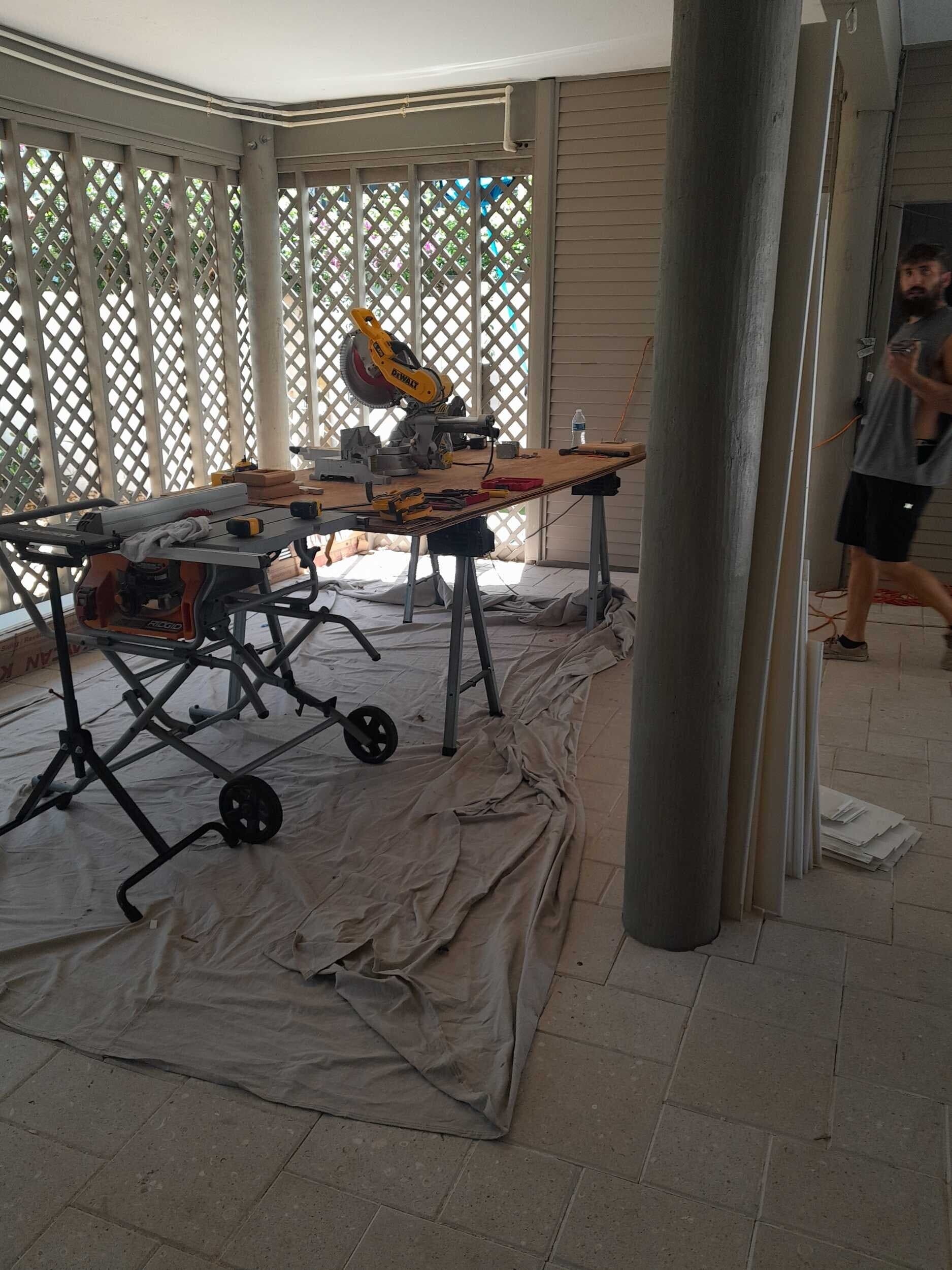 Contractors On Call carpenter setting up a miter saw on a St. Petersburg porch for trim cuts